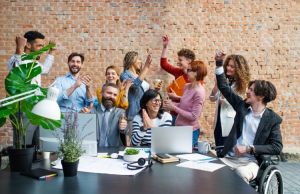 A group of smiling employees celebrate a positive workplace culture.