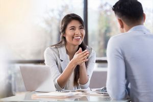 Woman listening and conversing at conference room table