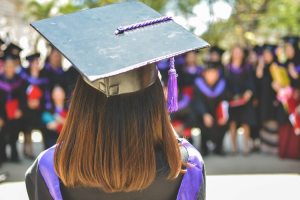 A graduate student in cap and gown at her commencement ceremony