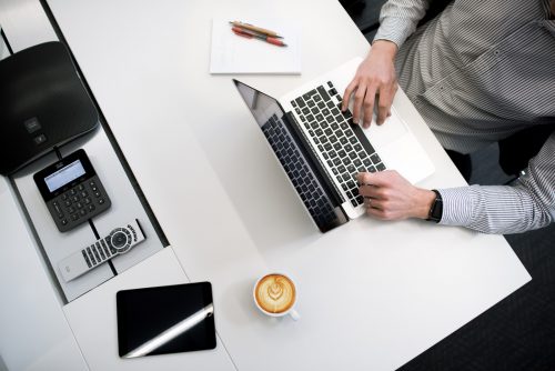 A close-up of a woman using a silver laptop.