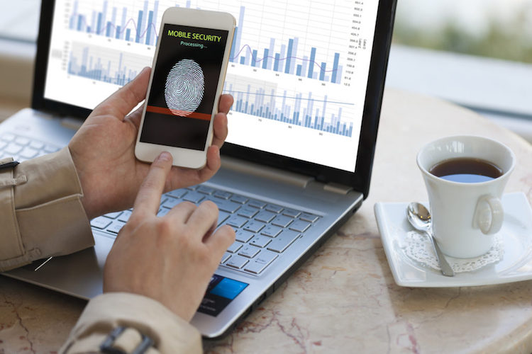 A business person accesses a smartphone using a security fingerprint feature.