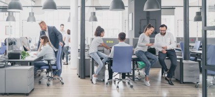 A group of entrepreneurs work in an open office setting.