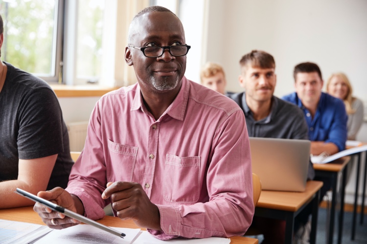 A middle-aged college student listens to a lecture. 