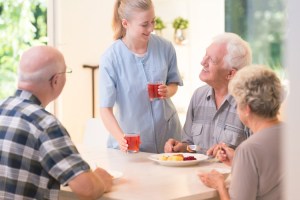 An adult day center staff member serves lunch.