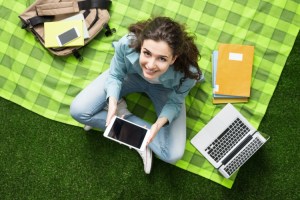 A student studies outside on a summer day.