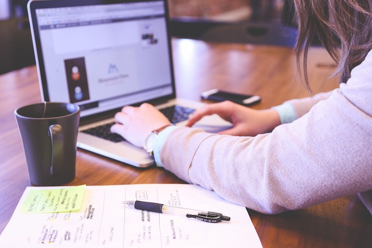 a person at their desk using their laptop