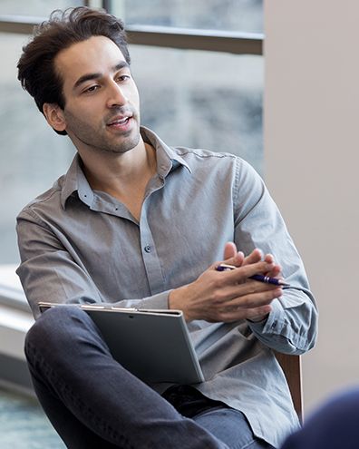 undergraduate student sitting with a tablet on his lap