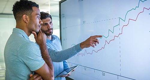 a group of men looking at a graph