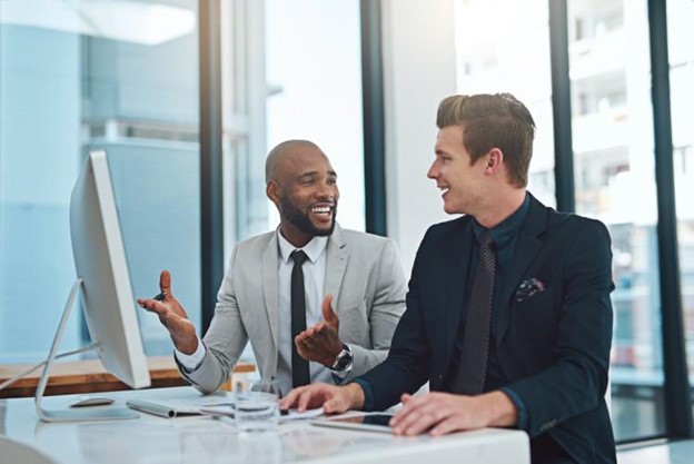 An MBA intern works with a mentor at a desk.