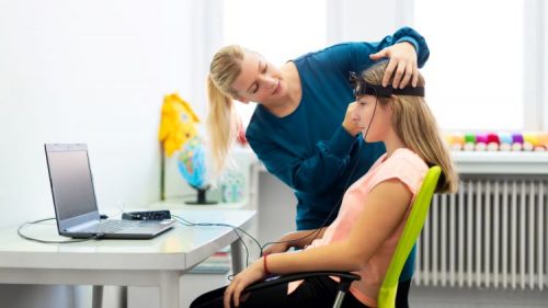 A psychiatric technician prepares a young patient for an EEG reading.