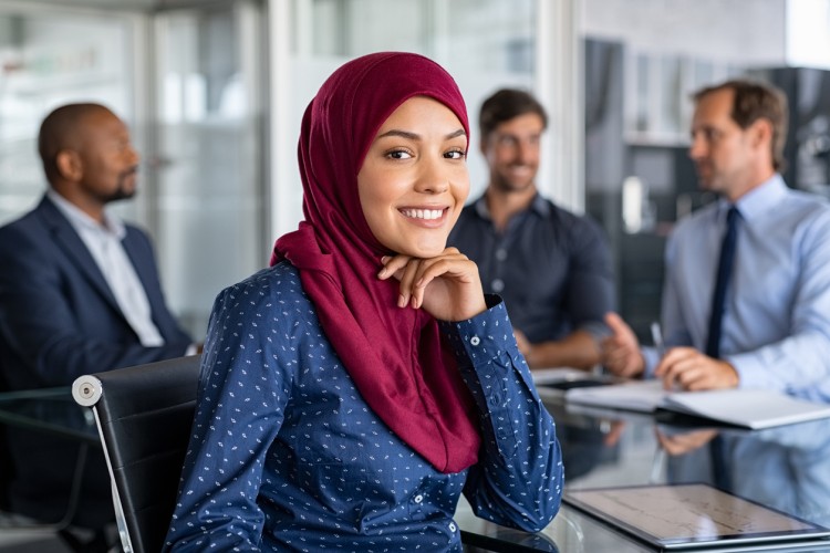 A smiling account executive at a conference table with an advertising team