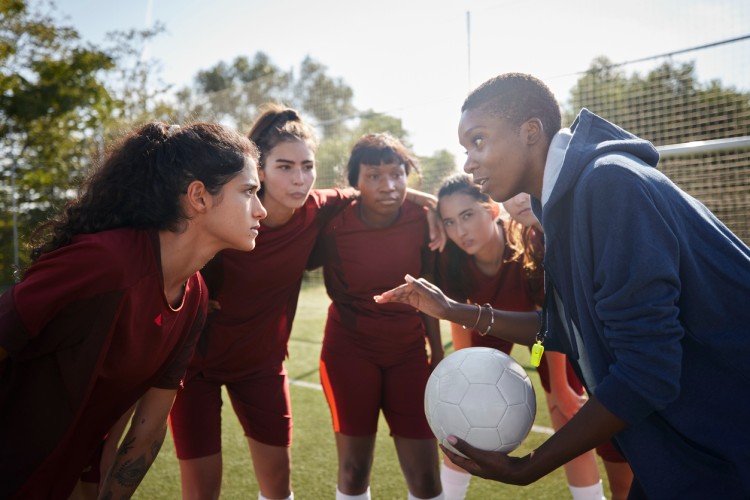 A soccer coach talks to a group of players.