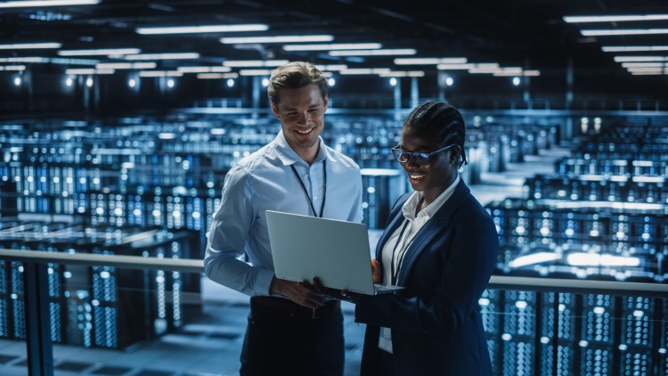 Computer and information professionals looking at a laptop in an information center