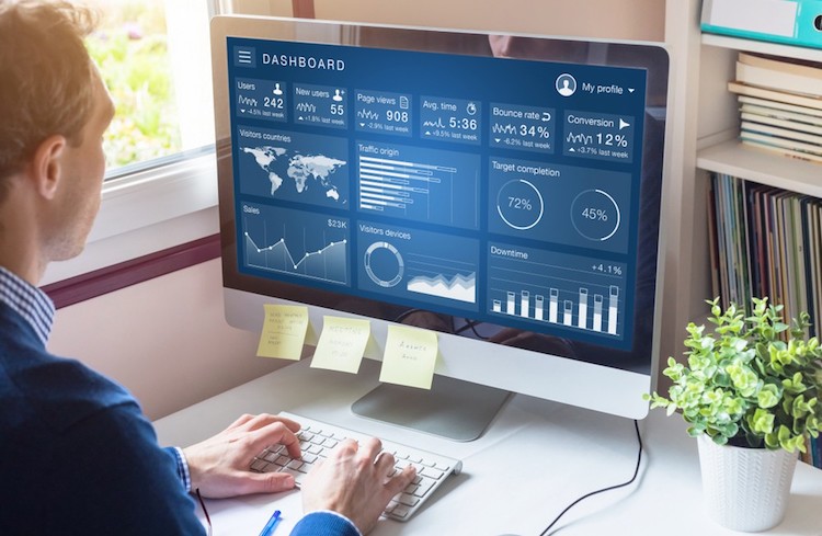 A professional digital marketer reviews analytic dashboard that displays website metrics.