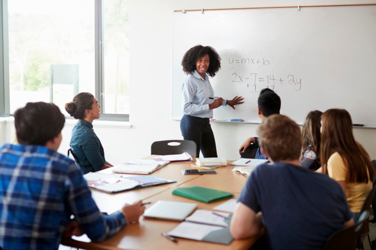 High school math teacher teaching to a group of students.