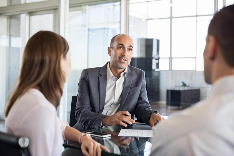 Group of professionals speaking at an office table