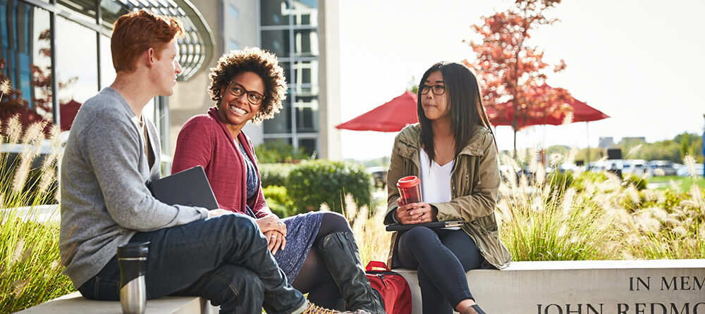 Group of students speaking at campus.