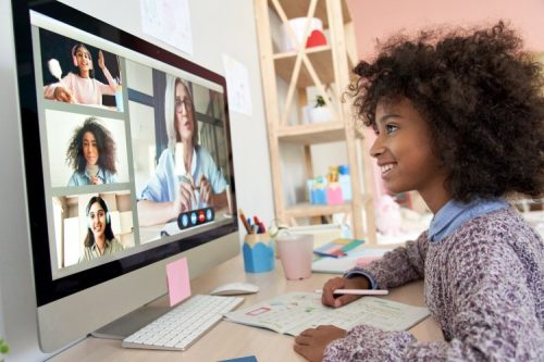 A teacher engages with students via video chat.