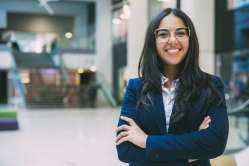 A smiling entrepreneur stands in an office hall