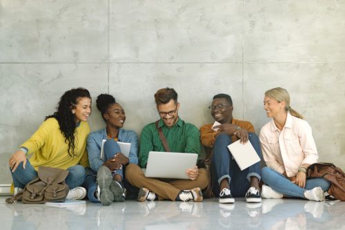 A group of college students looking at a laptop.