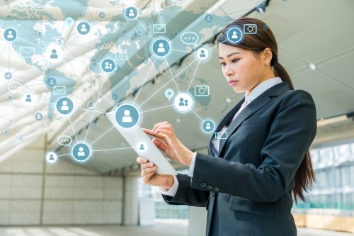 An advertising entrepreneur poses in front of a digital grid of mobile and tablet devices.